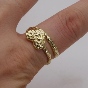 Dettaglio anello a cuore placcato oro 14k con trama lavica indossato al dito