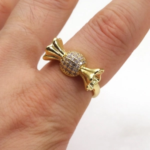 Dettaglio macro di un anello a forma di caramella placcato oro con zirconi cubici