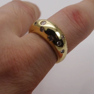 Detail of a 14k gold plated wide ring with micro-inset zircons on a model finger