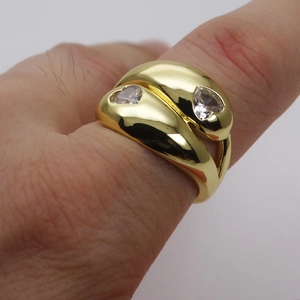 Detail view of a 14k gold plated wide band ring with two heart-shaped zircon stones