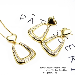 Detail of 14k gold plated heart necklace and earrings set with inlaid zircon stones