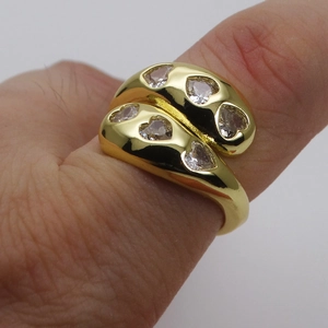 Close-up of a wide 14k gold plated ring with six micro-inlaid heart-shaped zircons