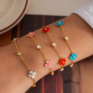 Elegantes pulseras de acero inoxidable con flores y circonitas mostradas en la muñeca