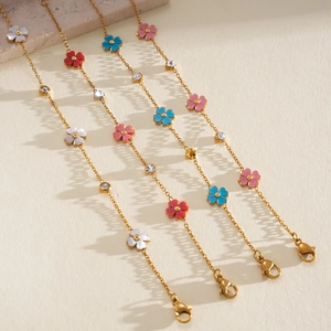 Detalle de pulseras de flores de nácar con acero inoxidable dorado y circonitas brillantes