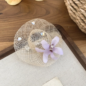 Gros plan d'un accessoire chapeau de paille miniature avec fleur en tissu violette