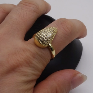 Detail of 14k gold plated pear shaped ring with micro pave cubic zirconia stones on finger