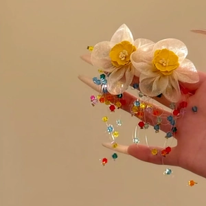 Detail van gele bloemenoorknopjes met kleurrijke kralenkwastjes voor vakantiestijl