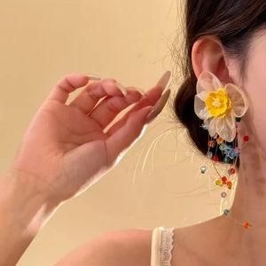 Detailopname van elegante gele bloemoorbellen in vakantiestijl met kleurrijke kralen