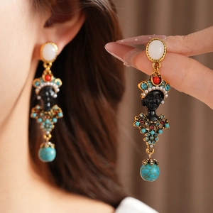 Detailed view of vintage-style resin portrait drop earrings with turquoise accents