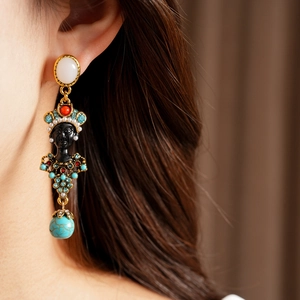 Detail shot of vintage portrait earrings with colorful rhinestones and turquoise bead.