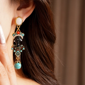 Detail of vintage portrait earrings with colorful rhinestones and turquoise bead