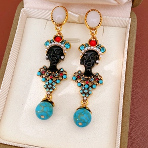 Close-up detail view of vintage portrait drop earrings with resin and crystal accents.