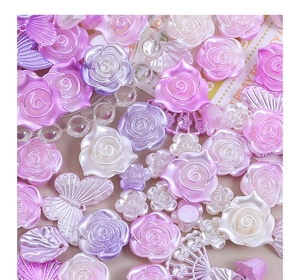 Dettaglio di rose e farfalle in resina perlata per creazioni fai-da-te viola e rosa