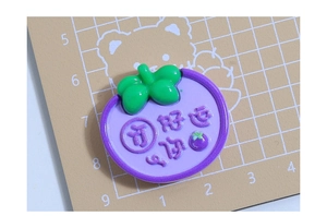 Détail d'un charme en résine mangoustan violet pour bricolage avec texte en relief