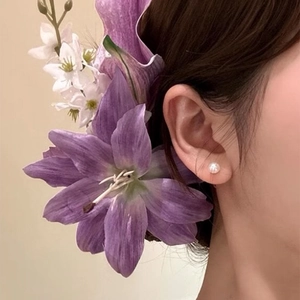 Close-up of a purple lily flower hair clip worn for a traditional Chinese style look