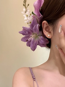 Detailed view of a purple lily hair clip worn for a New Chinese style elegant look