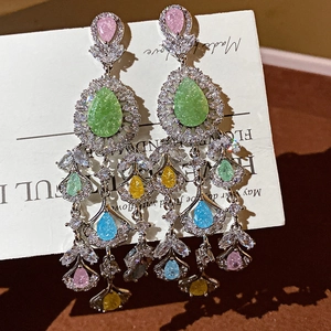 Gros plan de boucles d'oreilles pendantes en zircone colorée sur carte blanche