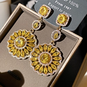Gros plan de boucles d'oreilles tournesol en zircon jaune dans un coffret cadeau de luxe