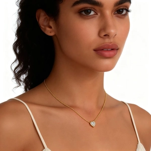 Nahaufnahme einer goldenen Herzanhänger-Halskette mit Kristallen an einem Model.