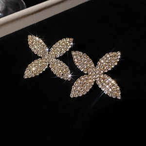 Gros plan de boucles d'oreilles clous en forme de fleur pavées de zircons brillants.