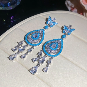 Detailed view of luxury silver drop earrings with butterfly studs and blue zircon stones