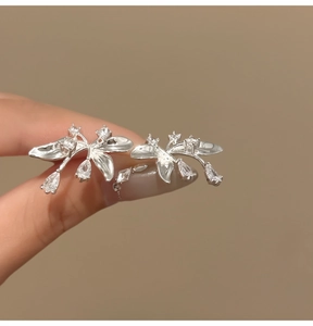 Primo piano dettagliato di orecchini a lobo a fiore in argento con cristalli