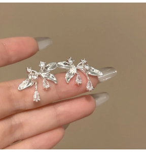 Primo piano di eleganti orecchini a lobo floreali in argento con cristalli a goccia