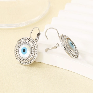 Détail des boucles d'oreilles œil en titane avec cristaux micro-pavés brillants