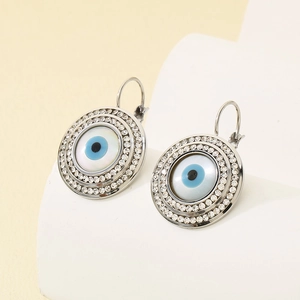 Vue détaillée de boucles d'oreilles œil protecteur argentées avec bordure en cristal