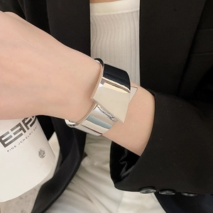 Detailed view of a silver geometric metallic cuff bracelet with a shiny finish