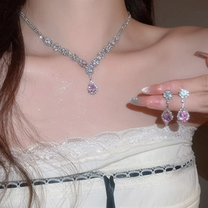 Detaillierte Nahaufnahme des eleganten rosa Zirkon Halsketten- und Ohrring-Sets am Modell