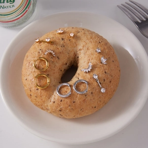 Macro view of various gold and silver stainless steel zircon earrings on a bagel.