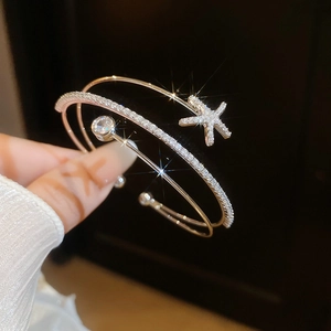 Close-up of a double-layer open bangle featuring a sparkling zircon star and gem detail.