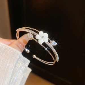 Close-up of elegant double-layer bangle with shell flower and sparkling cubic zirconia stones