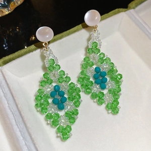 Gros plan détaillé des boucles d'oreilles en perles vertes style Jardin de Monet