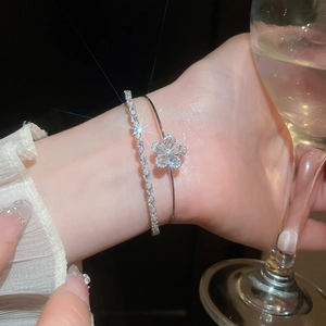 Close-up of elegant zircon flower double-layer bracelet worn on wrist at dinner party