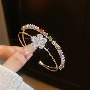 Macro detail of double-layer open bracelet featuring a sparkling zircon flower design.
