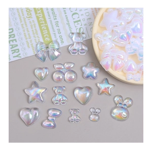 Flat lay of iridescent resin charms in heart and bear shapes for DIY crafts decoration
