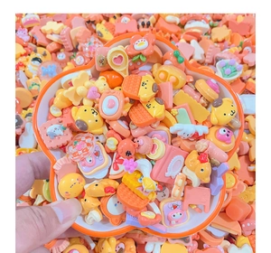 Close-up of assorted orange resin charms including cute animal and food shapes for DIY crafts