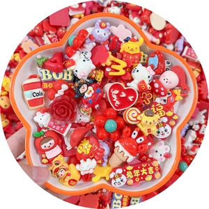 Red cartoon resin charms set for DIY crafts featuring various creative shapes in a tray
