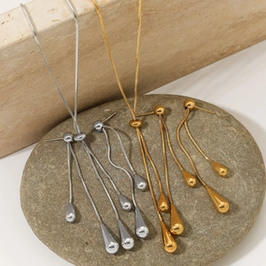 Macro detail of adjustable stainless steel water drop necklaces and earrings on stone