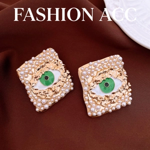 Elegantes pendientes vintage de perlas y oro con un diseño de ojo esmaltado verde central