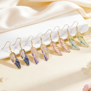 Detailed view of artistic gradient feather earrings in various colors displayed on white silk