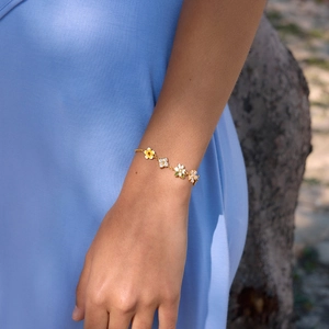 Detailed view of women's sweet style gold floral bracelet with zircon accents on wrist