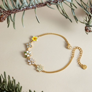 Detail shot of a gold stainless steel flower bracelet decorated with sparkling zircon stones.