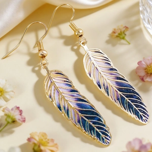Macro view of vintage feather earrings with intricate blue and purple enamel details.