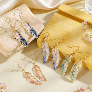 Detailed view of vintage colorful feather drop earrings with delicate leaf textures.