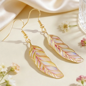 Close-up of colorful retro feather earrings with intricate leaf texture and gold hooks