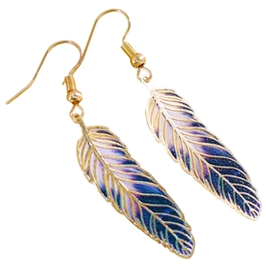 Detail shot of colorful vintage feather earrings with intricate leaf textures and gold hooks.