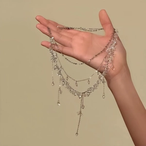 Detail view of multi-layered beaded necklace with elegant crystal-like drops and chains